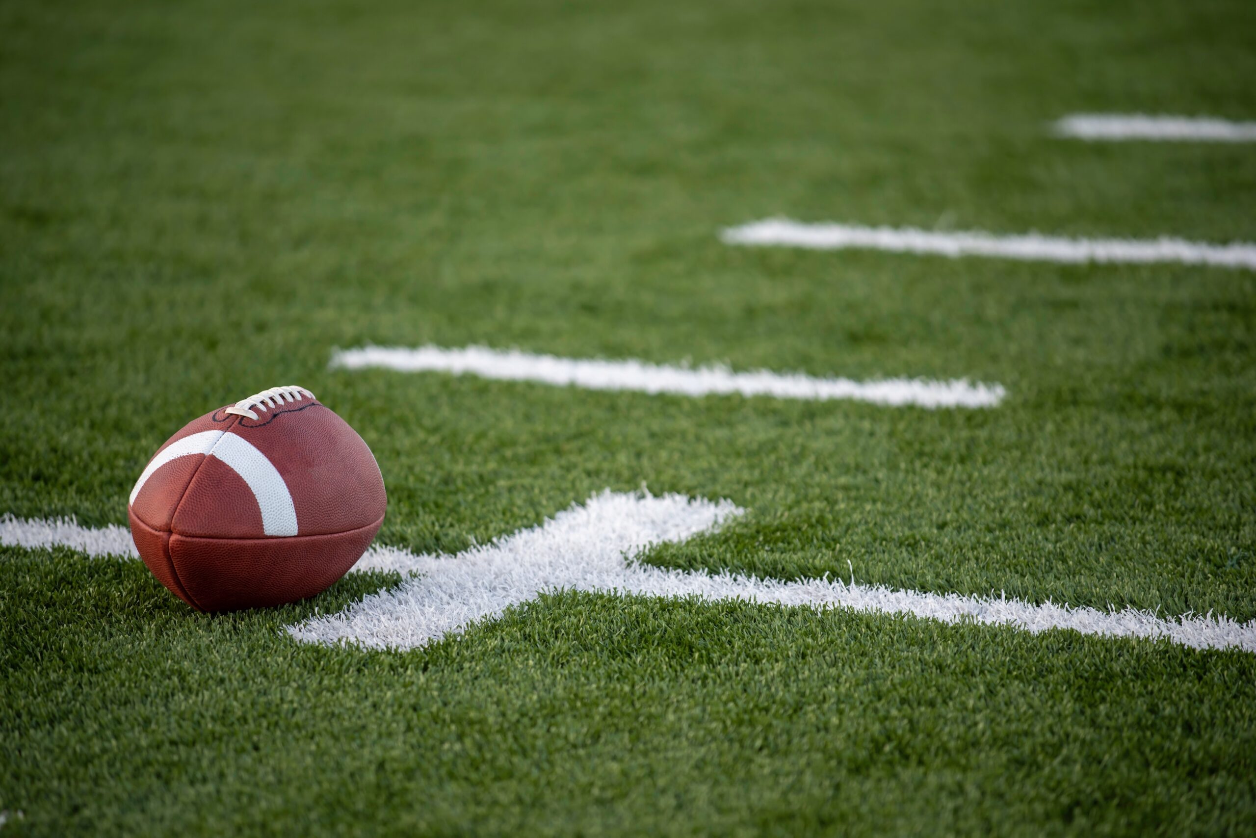 a brown leather American Football on a field